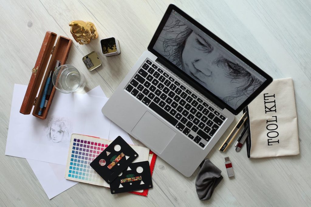 pexels-photo-414974 Top view of a creative workspace with a laptop, sketch supplies, and color palette.