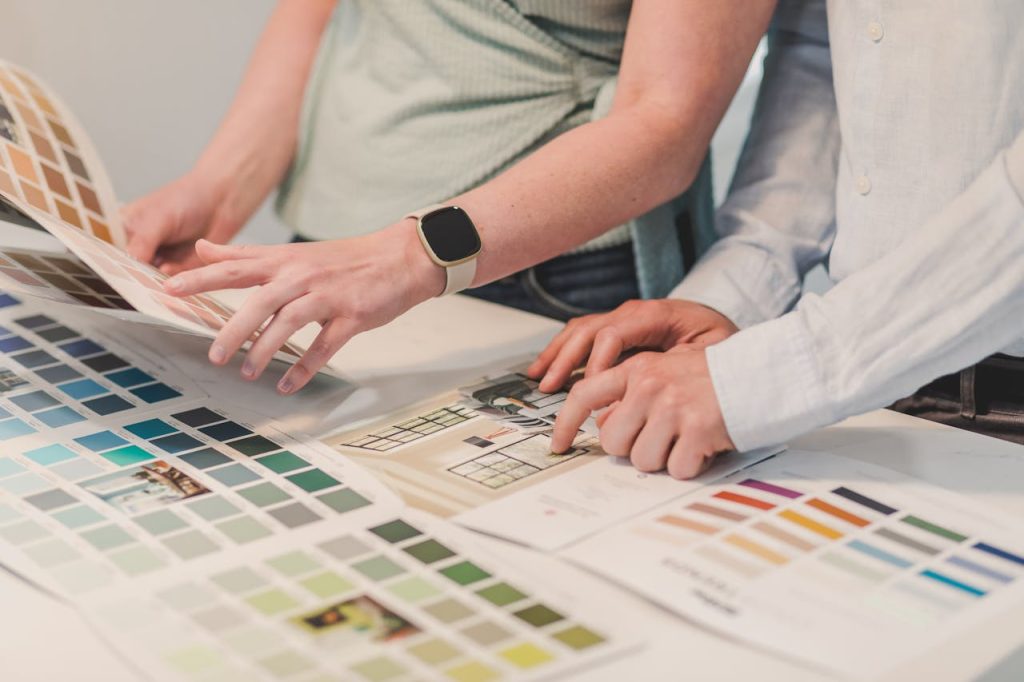 pexels-photo-8293668 Two people planning a project with color palettes on a table, collaborating creatively.